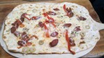 Flammkuchen aus dem Backofen mit Vegane Chorizo, Zwiebeln, Paprika, Oliven, Bergkäse 